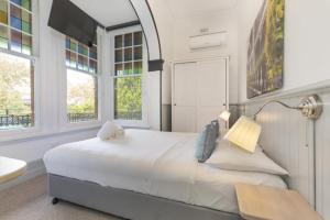 悉尼达尔齐尔酒店的白色卧室设有大床和窗户