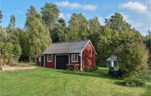 米约尔比Amazing Home In Hagalund-mjlby With Wifi的院子里带野餐桌的红色谷仓