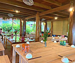 Làng BangPu Luong May Home & Cafe的餐厅里一张大木桌,配有桌椅