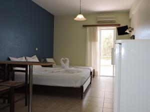 菲尼孔塔Sirios的一间卧室配有一张床铺、一张桌子和一台冰箱