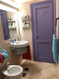 圣特雷莎加卢拉Villetta Reparata的一间带水槽和紫色门的浴室