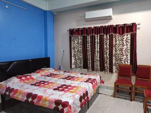 阿加尔塔拉Ujjayanta Homestay的一间卧室配有一张床和两把椅子