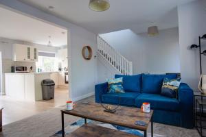 Sunbury CommonSAXON ROAD - A 3 Bedroom House with Garden by Prestigious Stays - Includes Wifi, Netflix & Amazon Alexa的客厅配有蓝色的沙发和桌子
