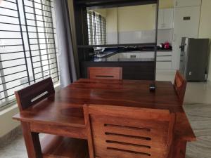 班加罗尔Castle JP Deluxe的厨房里配有一张木桌和椅子