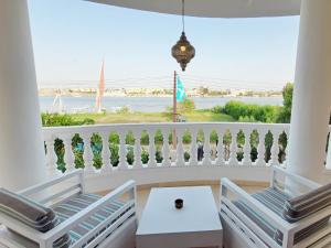 卢克索IN LUXOR Nile Apartments的阳台配有两把椅子,享有海景。