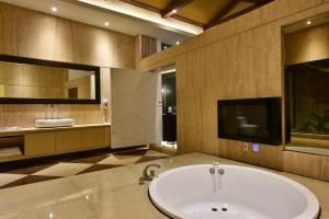 台中市台中威尼斯汽车旅馆的带浴缸的大型浴室和电视。