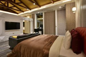 台中市台中威尼斯汽车旅馆的一间卧室配有一张床、一张沙发和一台电视。