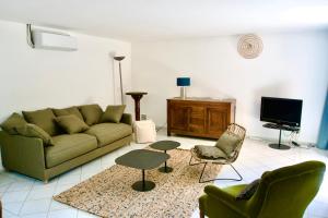 卡西斯L'ATELIER - Piscine - Dans les vignes - Cassis的客厅配有沙发、椅子和电视