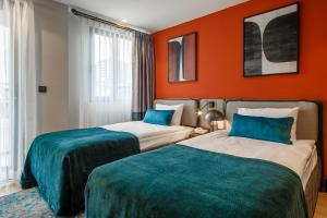 安塔利亚Sherwood Premio Hotel的橙色墙壁客房的两张床