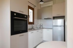 吉亚洛瓦吉亚洛瓦全景公寓的厨房配有白色橱柜和不锈钢冰箱