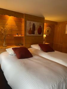 Beaumont-en-Auge普蒂特比尤蒙特酒店的卧室设有两张木墙