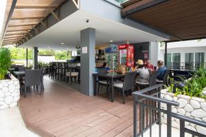 Ban Tha FatMantra Beach condominium M257的一家餐厅,人们坐在露台上的桌子上