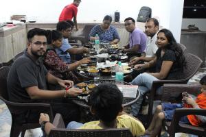 Manī MājraHotel Red Apple Near Railway Station Chandigarh的一群坐在桌子旁吃食物的人