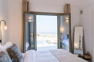 Éxo GoniáLavadoze Luxury Suites的一间卧室设有一张床和一个滑动玻璃门