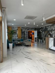 阿克托比KRich Hotel Aktobe的大堂设有大理石地板和沙发。