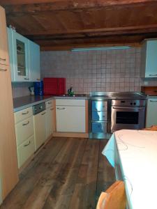 坎波图雷斯Ferienwohnung Oberpursteinhof的厨房配有白色橱柜和炉灶烤箱。
