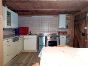 坎波图雷斯Ferienwohnung Oberpursteinhof的厨房配有白色橱柜和炉灶。