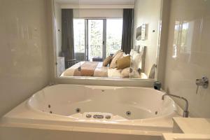 金斯克里福Peppers Balé Luxury Beach Accommodation Kingscliff - privately let的浴室设有白色浴缸及镜子