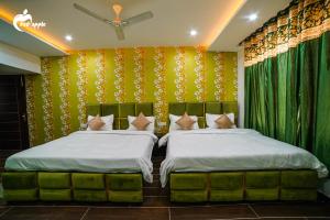 Manī MājraHotel Red Apple Near Railway Station Chandigarh的绿黄色壁纸客房的两张床