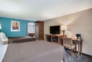 卡莱尔Rodeway Inn的一间酒店客房,配有一张床和一台电视