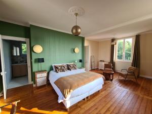 翁弗勒尔La Terrasse de l'Estuaire - Honfleur的一间卧室设有一张床和绿色的墙壁