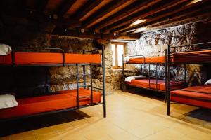 NavésCases Altes de Posada的石墙内带三张双层床的房间