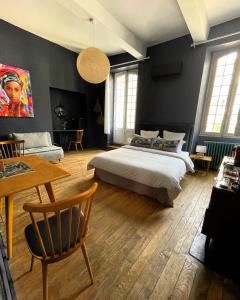 塔布La Maison aux murs anciens et ses chambres的卧室配有一张床和一张桌子及椅子