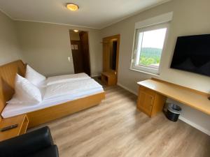 温特贝格温特贝格林尼普拉兹贝格酒店的一间小卧室,配有一张床和电视