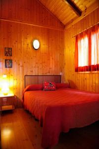 比利亚埃尔莫萨德尔里奥卡巴纳斯德伞巴特乐美酒店的木制客房内的一张红色床