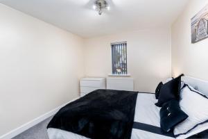 唐克斯特Boulevard View的白色卧室配有带黑色枕头的床