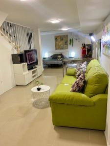 巴达洛纳BADAROSA 2 House10min to BARCELONCity&NearTo BEACH的客厅配有绿色沙发和电视