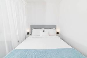特尔纳瓦White Innk city center apartment的白色卧室配有白色大床和蓝色床单