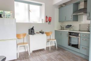 阿尔弗斯顿Remarkable 1-Bed Apartment in Ulverston的厨房配有蓝色和白色的橱柜,铺有木地板。