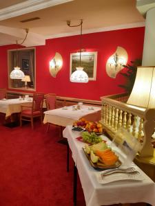 阿尔贝施文德Schedlers Löwenhotel-GARNI的餐厅设有白色的桌子和红色的墙壁