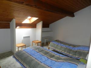 比斯卡罗斯海滩Les Flots Bleus Etage的一间卧室设有两张床和天窗