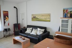 特雷莫西内Ferienwohnung-Casa-Uta-Gardasee-Limone-Tremosine的客厅配有黑色沙发和桌子