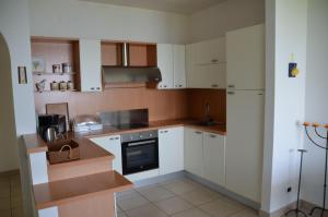 特雷莫西内Ferienwohnung-Casa-Uta-Gardasee-Limone-Tremosine的厨房配有白色橱柜和炉灶烤箱。