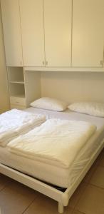 特雷莫西内Ferienwohnung-Casa-Uta-Gardasee-Limone-Tremosine的白色橱柜内的2张白色床