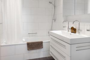阿罗萨Pranursa的白色的浴室设有水槽和浴缸。