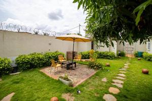 洛美Villa Damas的庭院里设有带桌子和遮阳伞的庭院。