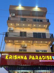 德奥加尔Hotel Krishna Paradise的建筑的侧面有标志