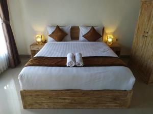 珀尼达岛Bukit keker cottage的一间卧室配有一张床,上面有两条毛巾