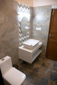 马拉利库兰玛拉里艾登旅馆的一间带水槽、卫生间和镜子的浴室