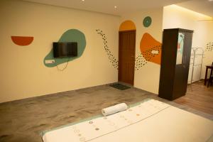 马拉利库兰玛拉里艾登旅馆的一间设有电视的墙壁和地板的客房
