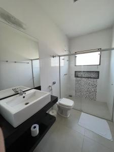 卡皮托利乌Pousada Pé da Serra的白色的浴室设有水槽和卫生间。