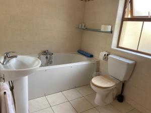 巴林斯凯利格斯Chapel Cross House的带浴缸、卫生间和盥洗盆的浴室