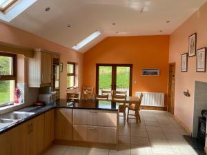 巴林斯凯利格斯Chapel Cross House的厨房拥有橙色的墙壁和桌椅
