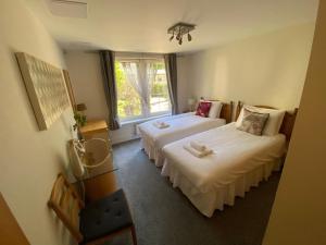 爱丁堡Hopetoun Apartment with free parking的酒店客房设有两张床和窗户。