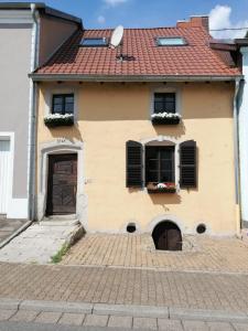 萨尔路易斯Ferienwohnung, Charmantes Bauernhaus, Ferienhaus的黄色的房子,有两个窗户和门