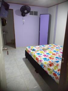 伊瓦格montecarlos hotel的一间卧室配有一张带五颜六色棉被的床